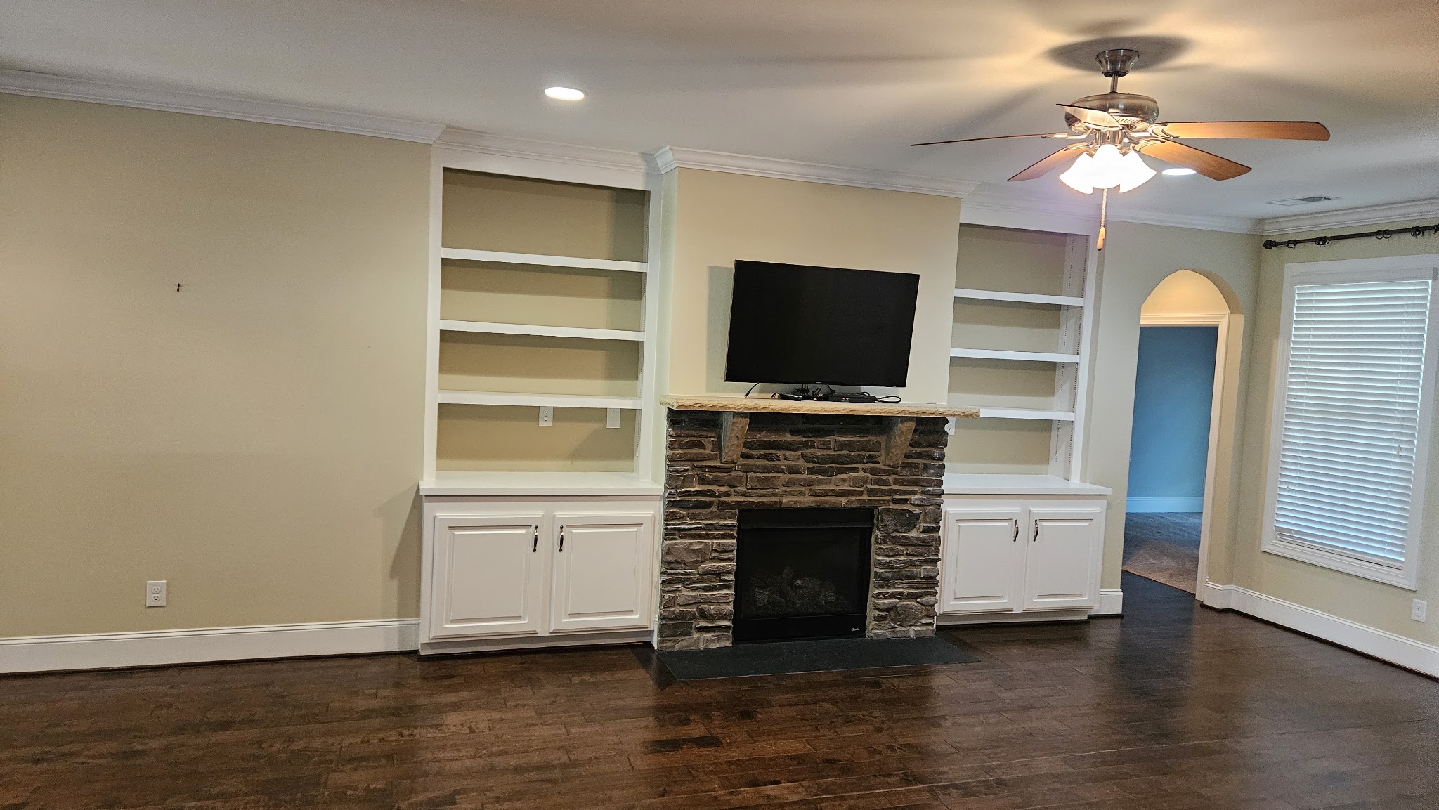 Living room with fireplace and hardwood floors after cleaning